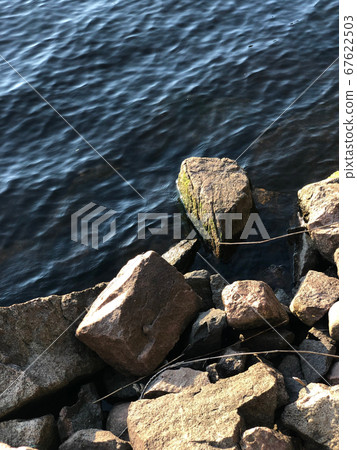 View of the blue lake from the rocky shore, 67622503