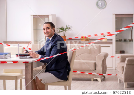 Young male employee working at home during pandemic disease 67622518