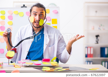 Young male medic in conflicting priorities concept 67622897