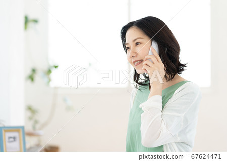 A middle woman who calls on a smartphone [Living] 67624471
