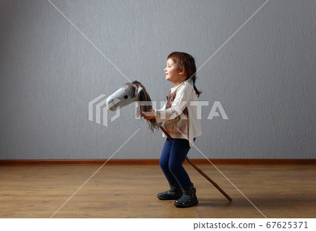 Cute little girl dressed like a cowboy playing 67625371