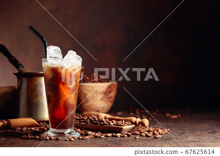 Ice coffee with cream being poured into it showing Ice coffee with cream being poured into it showing 67625614
