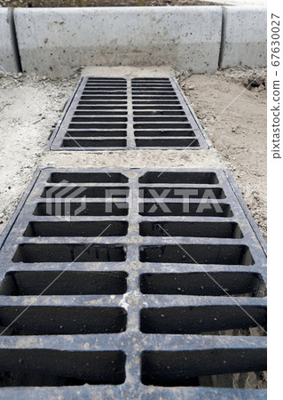 New rainwater grate on the road or sidewalk, New rainwater grate on the road or sidewalk, 67630027