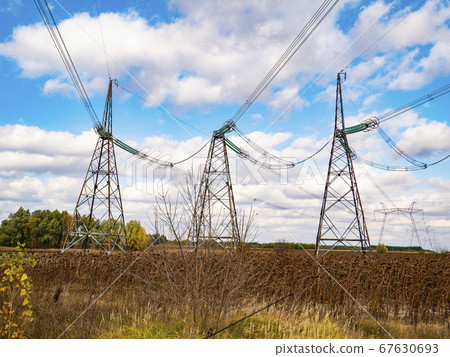 Towers of high-voltage energy transfer against a cloudy sky. 67630693