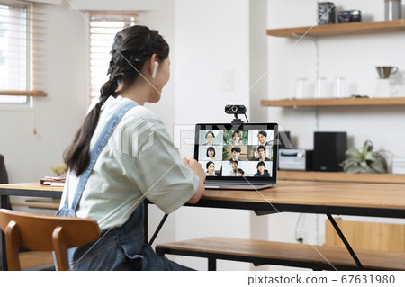 Rear view of a young woman attending an online meeting 67631980