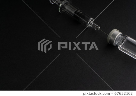 Closeup syringe and vials on black background 67632162
