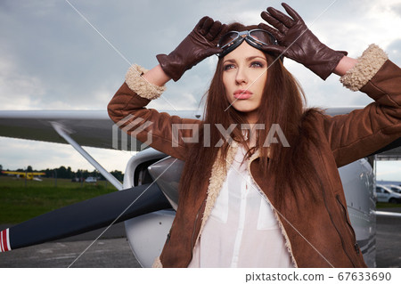 Attractive woman pilot wearing sunglasses standing 67633690