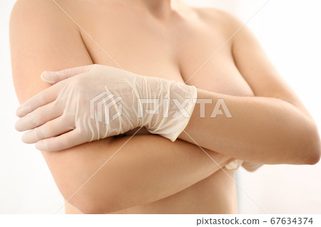 Woman closing naked chest with her arms Woman closing naked chest with her arms 67634374