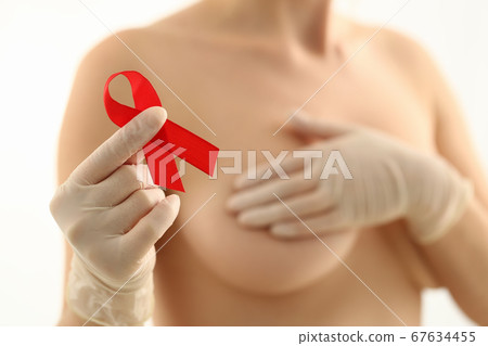 Woman expressing fighting against breast cancer with red tape 67634455