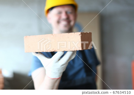 Happy male builder in yellow helmet enjoying his work 67634510