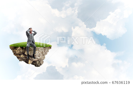 Young man on floating island do not want to hear anything 67636119