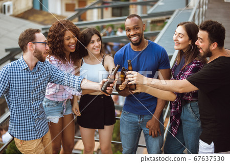 Group of happy friends having beer party in summer day. Resting together outdoor, celebrating and relaxing, laughting. Summer lifestyle, friendship concept. 67637530