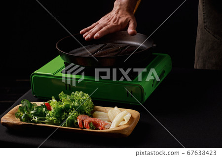 Chef cooks seafood, shrimp in a pan with vegetables. Chef cooks seafood, shrimp in a pan with vegetables. 67638423