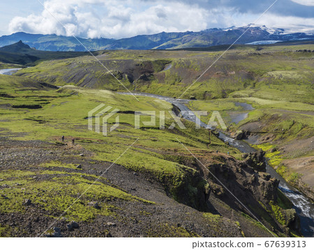 Beautiful lush green Landscape of Skoga river valley cascades near Skogafoss waterfall and Skogar end of Fimmvorduhals hiking trail. South Iceland, Summer blue sky Beautiful lush green Landscape of Skoga river valley cascades near Skogafoss waterfall and Skogar end of Fimmvorduhals hiking trail. South Iceland, Summer blue sky 67639313