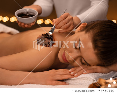 Female therapist applying exfoliating mask on woman body Female therapist applying exfoliating mask on woman body 67639550