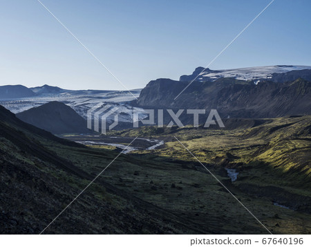 Icelandic landscape with eyjafjallajokull glacier tongue, Markarfljot river and green hills. Fjallabak Nature Reserve, Iceland. Summer blue sky 67640196