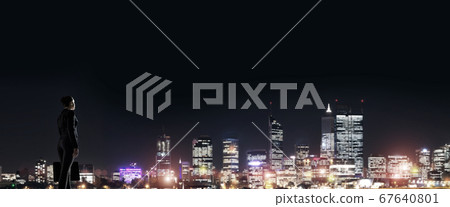 Businesswoman viewing night glowing city 67640801