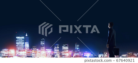 Businessman viewing night glowing city Businessman viewing night glowing city 67640921