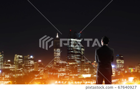 Businessman viewing night glowing city 67640927