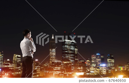 Businessman viewing night glowing city 67640930