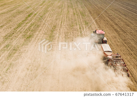 Aerial View. Tractor With Seed Drill Machine Sowing The Seeds For Crops In Spring Season. Beginning Of Agricultural Spring Season. Countryside Rural Field Landscape Aerial View. Tractor With Seed Drill Machine Sowing The Seeds For Crops In Spring Season. Beginning Of Agricultural Spring Season. Countryside Rural Field Landscape 67641317