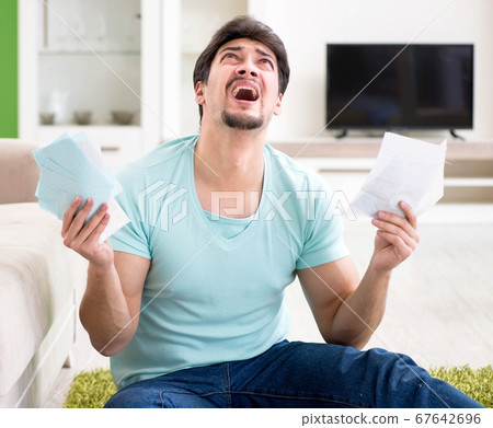 Young man struggling with personal finance and bills 67642696