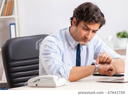 Young handsome businessman working in office 67642789
