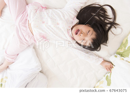 A girl sleeping in bed 67643075