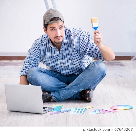 Young man contractor choosing color from rainbow Young man contractor choosing color from rainbow 67643207