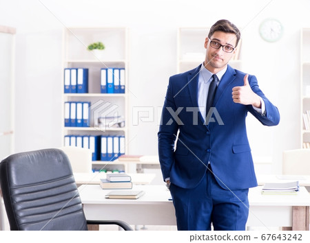 Young handsome businessman employee working in office at desk Young handsome businessman employee working in office at desk 67643242