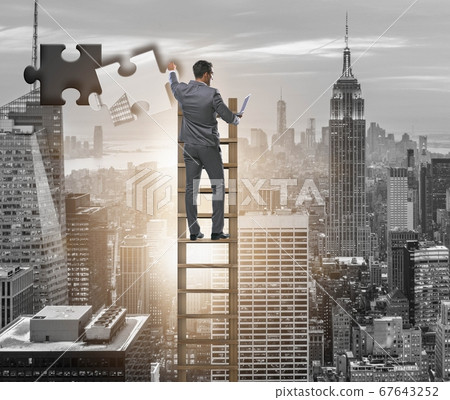 Businessman putting together jigsaw puzzle pieces Businessman putting together jigsaw puzzle pieces 67643252
