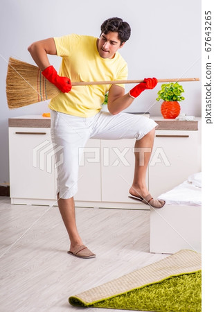 Young handsome man cleaning in the bedroom Young handsome man cleaning in the bedroom 67643265