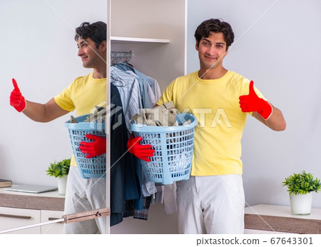 Young handsome man cleaning in the bedroom 67643301