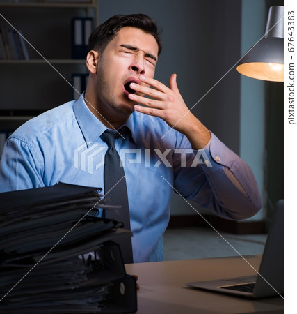 Employee working late at night at important report 67643383