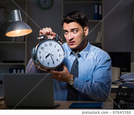 Young employee working overtime to meet deadline Young employee working overtime to meet deadline 67643388