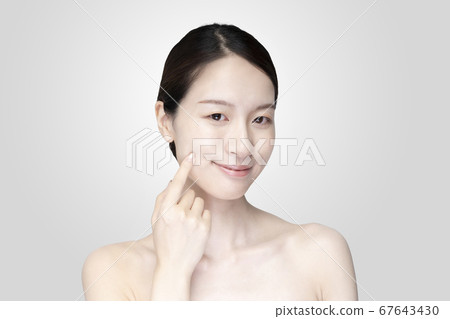 年輕女子撫摸她的臉與輕鬆的表情 年輕女子撫摸她的臉與輕鬆的表情 67643430