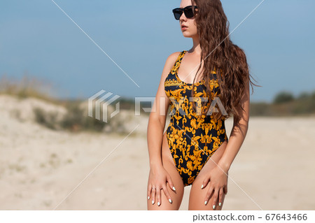 Slim woman in swimwear looking away 67643466