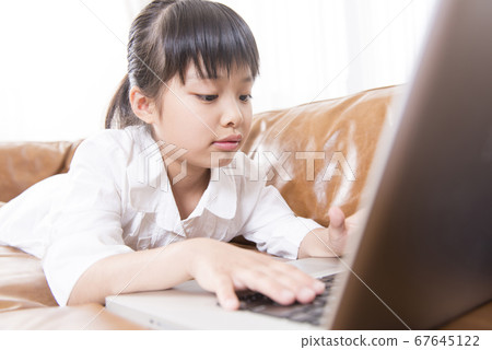 A girl playing a laptop 67645122