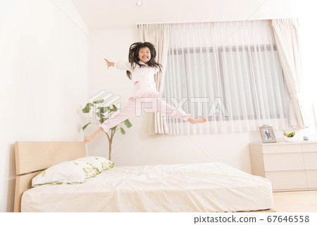 Girl jumping in bed 67646558