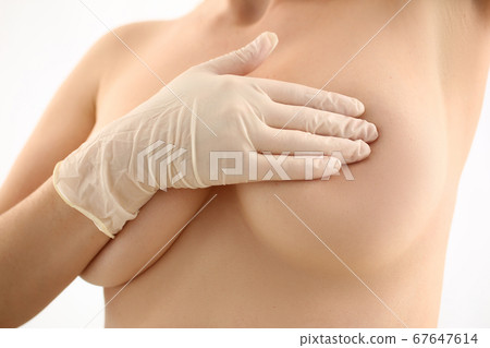 Female examining her breast for avoiding cancer Female examining her breast for avoiding cancer 67647614