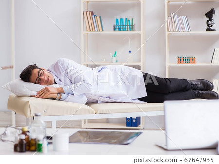 Doctor relaxing after complex surgery in hospital Doctor relaxing after complex surgery in hospital 67647935