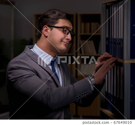 Businessman almost falling asleep working late hours in the offi Businessman almost falling asleep working late hours in the offi 67649010