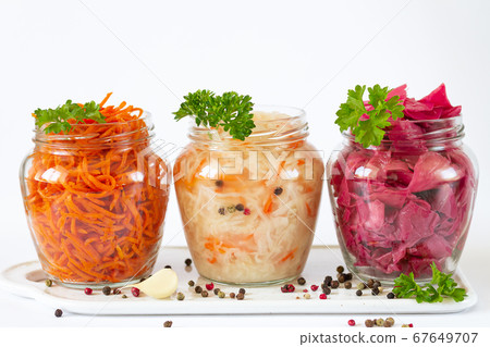 Pickled and fermented homemade vegetables. Sauerkraut, marinated red cabbage and carrot in glass jars with copy space Pickled and fermented homemade vegetables. Sauerkraut, marinated red cabbage and carrot in glass jars with copy space 67649707