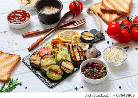 Healthy vegetarian grilled table with bbq gluten free bread and vegetables (zucchini, eggplant, carrot, lemon) 67649969