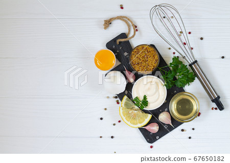 Fresh mayonnaise sauce with ingredients preparing mayo on white wooden table top view	 67650182