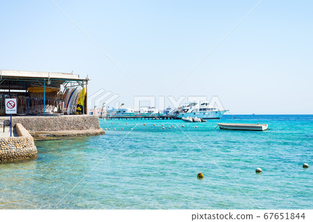Seascape with stone coastline and parked boats. 67651844