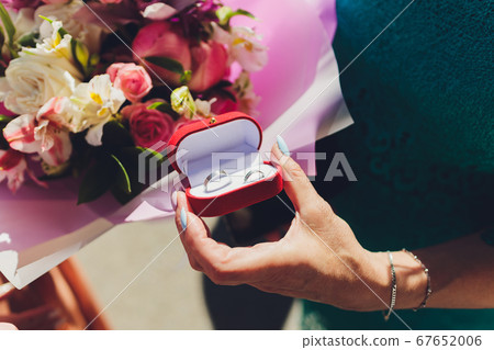 Close up of man holding wedding ring and gift box. Close up of man holding wedding ring and gift box. 67652006