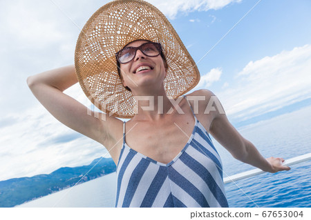 Beautiful, romantic blonde woman taking selfie self portrait photo on summer vacations traveling by cruse ship ferry boat. Beautiful, romantic blonde woman taking selfie self portrait photo on summer vacations traveling by cruse ship ferry boat. 67653004