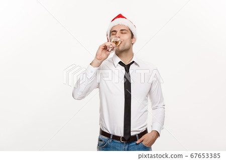 Christmas Concept - Handsome Business man celebrate merry christmas and happy new year wear santa hat with glass of champange. Christmas Concept - Handsome Business man celebrate merry christmas and happy new year wear santa hat with glass of champange. 67653385