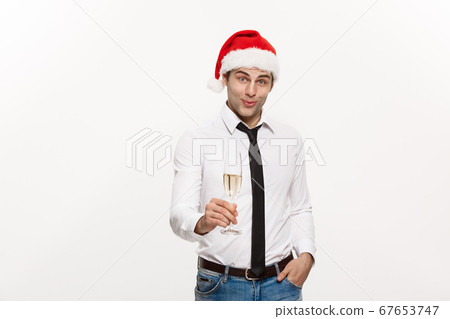 Christmas Concept - Handsome Business man celebrate merry christmas and happy new year wear santa hat with glass of champange. Christmas Concept - Handsome Business man celebrate merry christmas and happy new year wear santa hat with glass of champange. 67653747